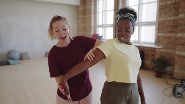 若いアフリカ系アメリカ人女性は スタジオで白人女性教師とプライベートレッスン中にダンスの動きを学ぶ — ストック動画