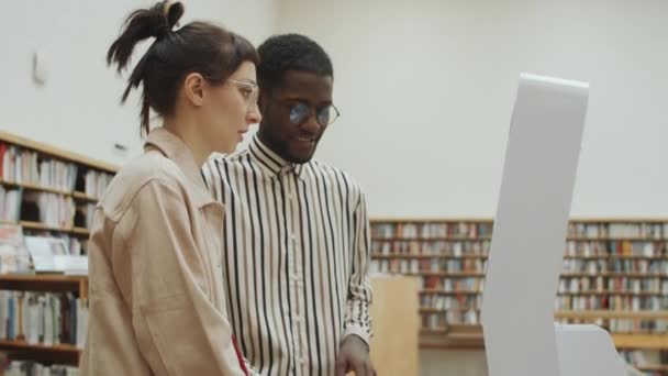 Mladá Běloška Afroameričan Stojí Knihovně Používají Interaktivní Digitální Displej Mluví — Stock video