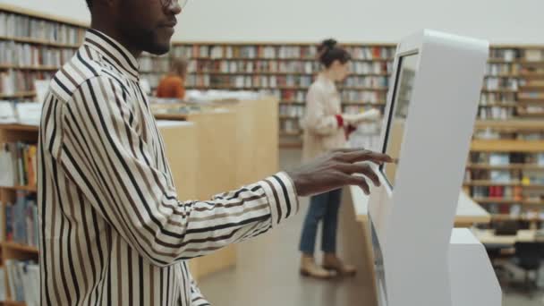 Střední Snímek Afroameričana Pomocí Interaktivního Digitálního Displeje Knihovně — Stock video