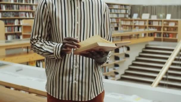 Zdjęcia Afro Amerykanina Luźnym Stroju Stojącego Bibliotece Czytającego Książkę — Wideo stockowe