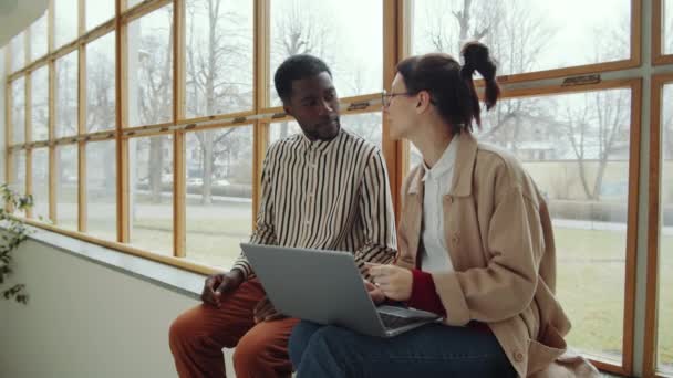 Mladý Afroameričan Běloška Sedí Společně Okenní Římse Moderní Budově Používají — Stock video