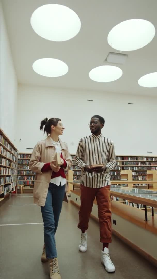 Vertikální Záběr Mladého Afrického Muže Bělošky Kráčející Knihami Knihovně Mluvící — Stock video