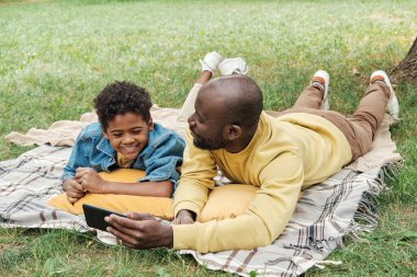 Baba oğul cep telefonu kullanıyor.