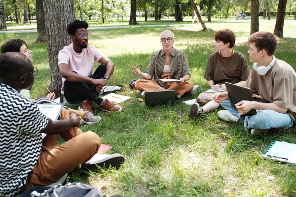 Profesor con estudiantes que estudian al aire libre — Foto de Stock