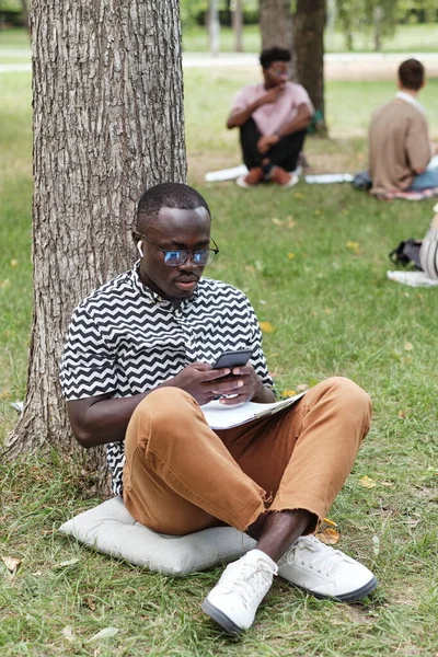 Student using phone outdoors — Stock Photo, Image