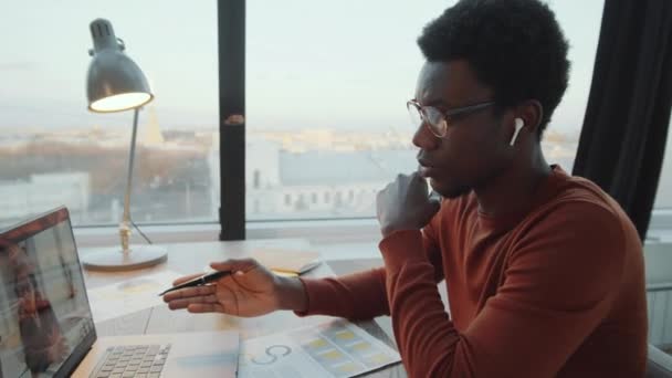 Afroamerykański Biznesmen Bezprzewodowych Słuchawkach Siedzi Przy Biurku Biurze Dachu Rozmawia — Wideo stockowe