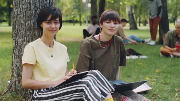 Retrato Dos Jóvenes Universitarias Sentadas Con Portátil Portapapeles Césped Parque — Vídeos de Stock