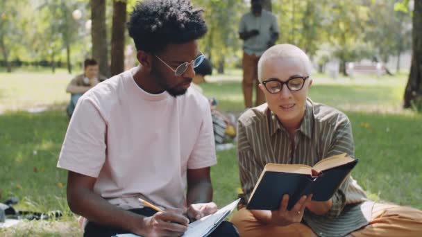 Maestra Caucásica Leyendo Libro Hablando Con Estudiante Afroamericano Mientras Toma — Vídeos de Stock