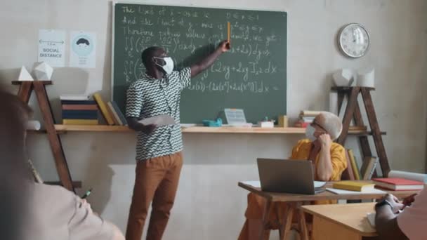 Estudiante Afroamericano Máscara Protectora Explicando Fórmulas Matemáticas Pizarra Compañeros Clase — Vídeos de Stock