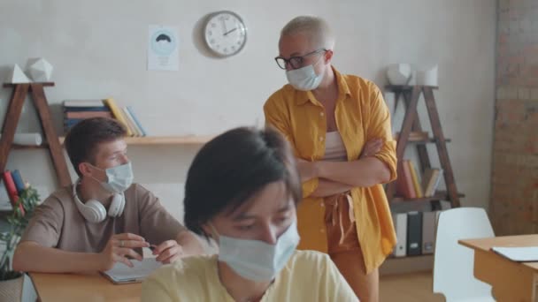 Vrouwelijke Leraar Wegwerpmasker Lopen Klas Tijdens Les Praten Met Multi — Stockvideo