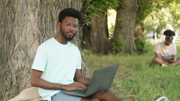 Портрет Молодого Афро Американського Чоловіка Окулярах Каретному Одязі Сидячи Дереві — стокове відео