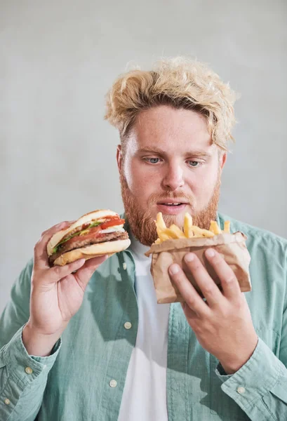 Giovane che mangia fast food — Foto Stock