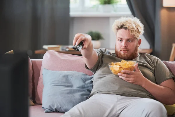 Надмірна вага людини дивитися телевізор вдома — стокове фото