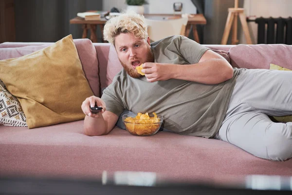 Luie man potato chips eten en kijken naar Tv — Stockfoto