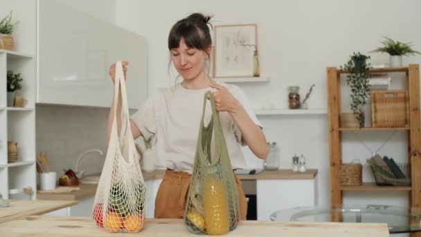 年轻美丽的女人走进厨房 从环保网袋里卸下新鲜的有机食品 — 图库视频影像