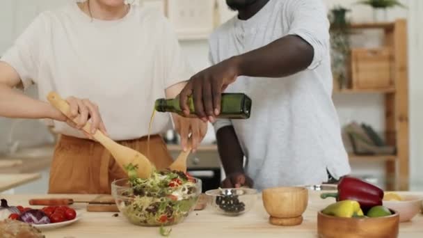 Afrikalı Kocası Zeytinyağı Eklerken Beyaz Bir Kadının Sebze Salatasını Kaseye — Stok video