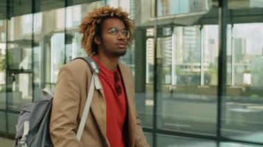 Genç Afro-Amerikan iş adamının şehrin caddesinde elektrikli scooter sürerken ki görüntüsü.