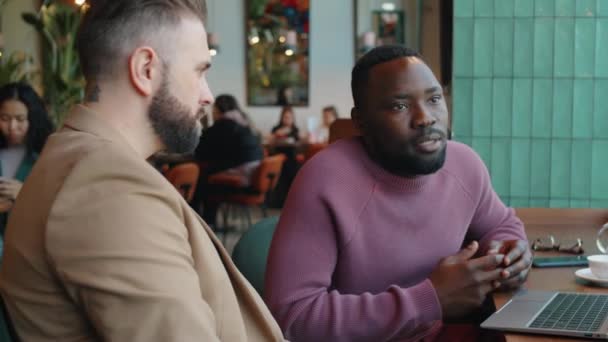 Afro Amerikaanse Man Bespreekt Project Laptop Met Blanke Mannelijke Collega — Stockvideo