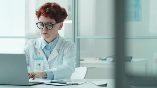 Mladá Doktorka Laboratorním Plášti Pracuje Notebooku Zapisuje Poznámky Stole Klinice — Stock video