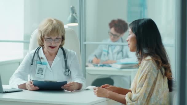 Senior Vrouwelijke Arts Die Medische Geschiedenis Van Vrouwelijke Patiënt Neemt — Stockvideo