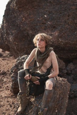 Dışarıdaki kayada oturan kadın.