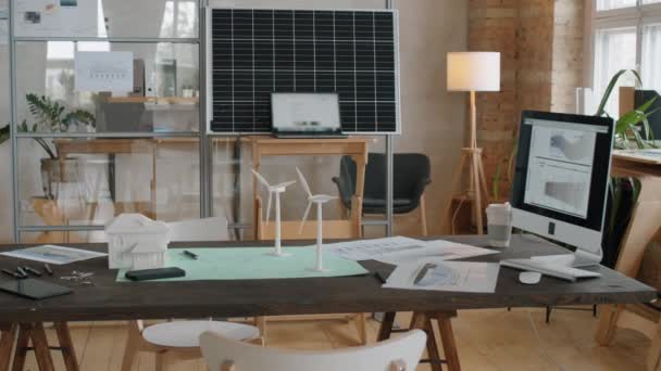 可再生能源公司的办公室内部有太阳能电池板和写字台 上面有造纸厂涡轮机和房子的纸型模型 — 图库视频影像