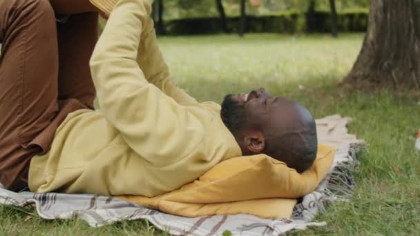 Incline Tiro Homem Afro Americano Alegre Deitado Parque Levantando Pequeno — Vídeo de Stock