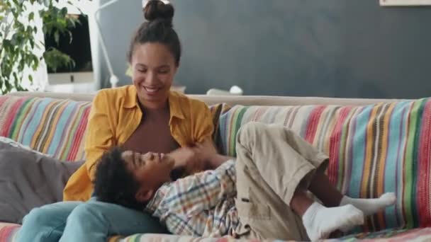Beautiful Afro American Woman Smiling Tickling Excited Little Son Sofa — ストック動画