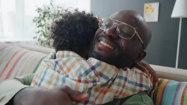 Маленький Афроамериканський Хлопчик Обіймає Щасливого Батька Любов Єднуючись Дивані Вдома — стокове відео