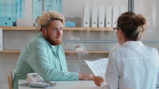 Jonge Man Met Overgewicht Geeft Medische Geschiedenis Aan Vrouwelijke Arts — Stockvideo