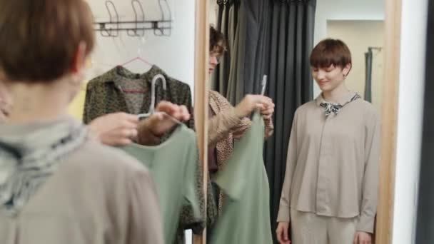 Male Assistant Helping Young Female Customer Choosing Dress Fitting Room — Stock Video