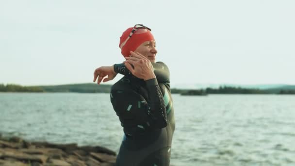 Kvinnlig Triathlet Baddräkt Står Stranden Och Gör Stretching Övningar Samtidigt — Stockvideo