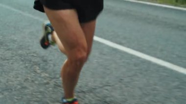 Beyaz kadın sporcu kadın sporcunun yaz günü triatlon yarışına hazırlanırken yolda koşarken çekimini yap.