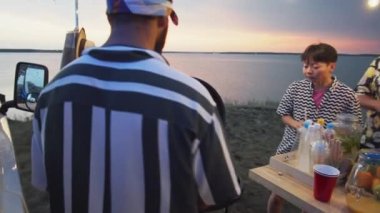 Yaz festivalinde genç çoklu etnik gruplar için sokak yemekleri yapan erkek satıcının PAN çekimi