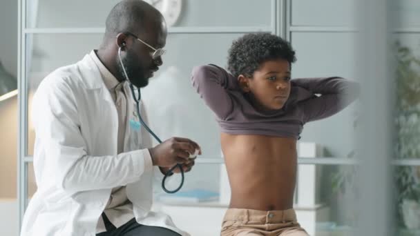 Beyaz Önlüklü Afrikalı Amerikalı Çocuk Doktoru Klinikte Ciğerlerini Kontrol Ederken — Stok video