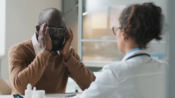 Schouder Van Afro Amerikaanse Man Klagen Hoofdpijn Bij Vrouwelijke Arts — Stockvideo