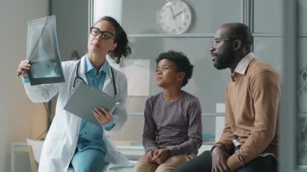Pediatra Mulher Explicando Radiografia Tórax Para Pai Afro Americano Menino — Vídeo de Stock