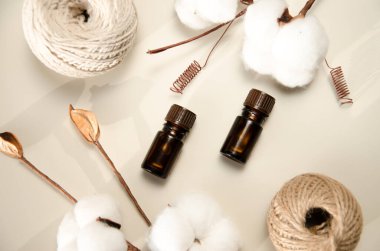 Bej arka planda çevre dostu biyokozmetik seti. Güzellik ürünleri - Kehribar cam damlatan şişeler ve pamuk yaprakları. Düz yatış, üst görünüm.