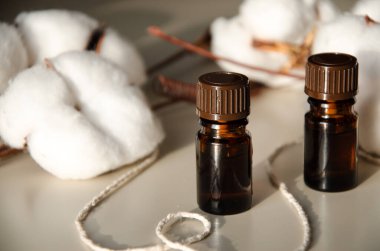 Bej arka planda çevre dostu biyokozmetik seti. Güzellik ürünleri - Kehribar cam damlatan şişeler ve pamuk yaprakları. Düz yatış, üst görünüm.