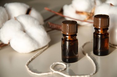 Bej arka planda çevre dostu biyokozmetik seti. Güzellik ürünleri - Kehribar cam damlatan şişeler ve pamuk yaprakları. Düz yatış, üst görünüm.