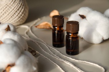 Bej arka planda çevre dostu biyokozmetik seti. Güzellik ürünleri - Kehribar cam damlatan şişeler ve pamuk yaprakları. Düz yatış, üst görünüm.