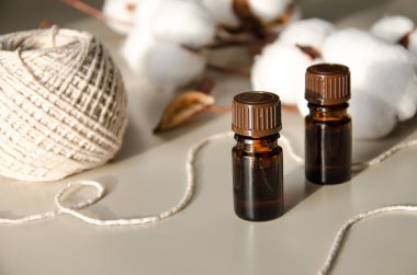 Bej arka planda çevre dostu biyokozmetik seti. Güzellik ürünleri - Kehribar cam damlatan şişeler ve pamuk yaprakları. Düz yatış, üst görünüm.