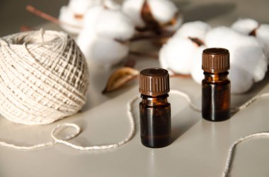 Bej arka planda çevre dostu biyokozmetik seti. Güzellik ürünleri - Kehribar cam damlatan şişeler ve pamuk yaprakları. Düz yatış, üst görünüm.