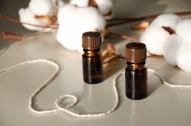 Bej arka planda çevre dostu biyokozmetik seti. Güzellik ürünleri - Kehribar cam damlatan şişeler ve pamuk yaprakları. Düz yatış, üst görünüm.