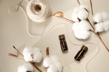 Bej arka planda çevre dostu biyokozmetik seti. Güzellik ürünleri - Kehribar cam damlatan şişeler ve pamuk yaprakları. Düz yatış, üst görünüm.