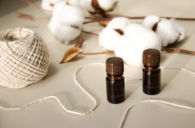 Bej arka planda çevre dostu biyokozmetik seti. Güzellik ürünleri - Kehribar cam damlatan şişeler ve pamuk yaprakları. Düz yatış, üst görünüm.