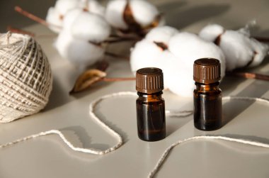 Bej arka planda çevre dostu biyokozmetik seti. Güzellik ürünleri - Kehribar cam damlatan şişeler ve pamuk yaprakları. Düz yatış, üst görünüm.