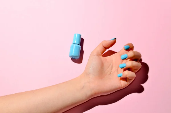 Shot of a woman hands with nail polishes isolated on pink purple background