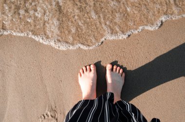 Kadınların ayakları kumsalda kumsalda