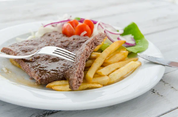 Hambúrgueres fritos e servidos com batata e saladas em um prato — Fotografia de Stock